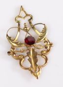 9 carat gold pendant, with scroll and leaf decoration, set with a central garnet, 4cm high, 1.2g