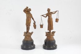 Pair of gilded spelter figures, in the form of figures carrying vessels and pails, 28cm and 30cm