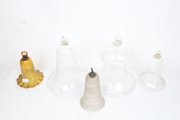 Five glass oil lamp smoke bells, to include a swirled amber coloured glass example, the largest 24cm