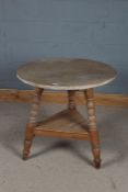 Stripped pine cricket table, the circular top above an under tier and raised on three legs, 74cm