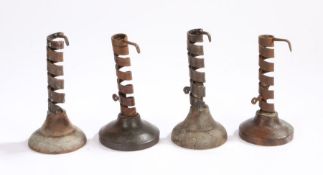 A collection of four wrought iron spiral candlesticks, on turned wooded bases, (4)
