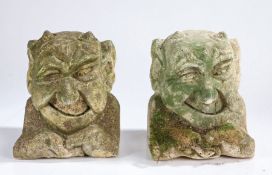 A pair of stone gargoyles, carved as demons with low horns protruding from the heads, 29cm high, (
