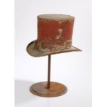 An amusing early 20th Century Tole Top hat trade sign, in red, raised on an associated stand,