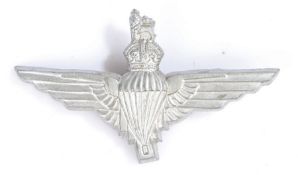 World War Two plastic economy cap badge to the Parachute Regiment, in silver grey, two blades to the