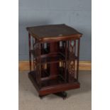 Edwardian revolving bookcase, the scroll marquetry inlaid top above book divisions with pierced