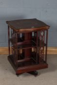 Edwardian revolving bookcase, the scroll marquetry inlaid top above book divisions with pierced