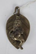 Indian silvered metal deity, possibly depicting infant Krishna laying on a leaf, 7.5cm wide, 13.