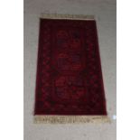 Super Keshan carpet, the red ground with triple elephant foot lozenge pattern centre and tasselled