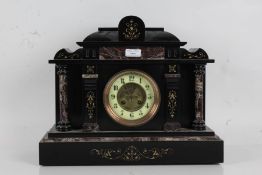 Victorian black slate mantle clock of architectural form, with a floral decorated pediment above