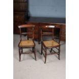 Pair of blade back dining chairs, with a carved rail and a cane seat raised on turned legs (2)