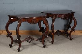 Pair of mahogany serpentine fronted console tables with foliate decoration, with saber legs united