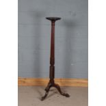 George III style mahogany torchere stand, with a circular pie crusted top on a foliate carved column