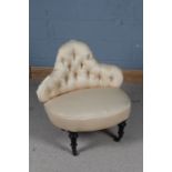 Late Victorian button back chair, having shaped back and raised on four ebonised legs and castors,