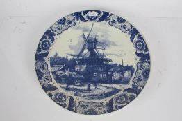 Dutch Delft plate depicting a scene of a windmill with a floral border, 39cm diameter