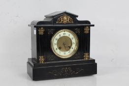 Victorian black slate mantle clock, with an arched pediment with cherubs above a pair of columns,