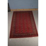 Large Middle eastern rug, the red ground with elephants foot design in red and gold and multiple