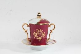 Limoges porcelain chocolate cup, cover and stand, the red ground with gilt foliate decoration,