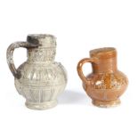 Two 16th century  pottery jugs, German, one with grey glaze, with facial sun burst and profiles to