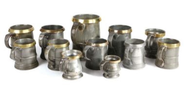 A group of 19th century brass rimmed pewter mugs, Of straight-sided and bulbous form, to include