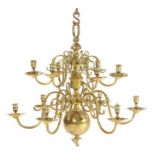 An impressive brass chandelier,with two graduated tiers of twelve scrolling candle branches,
