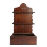 A George III oak spoon rack, circa 1800, the arched back plate with two spoon aperture rails, the