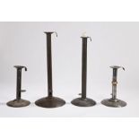 Four iron/steel hogscraper-type candlesticks, one with brass knop, two approximately 18cm high, and