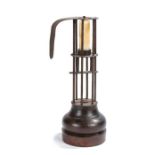 A wrought-iron and wooden 'birdcage' or stable candlestick, French, circa 1800-30, topped with a