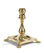 Early 18th Century candlestick, the socket above a baluster column and square base raised on four
