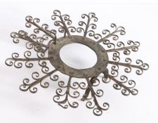 An 18th century iron trivet, the central circular frame with radiating multiple scroll arms, above