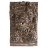 A  carved oak lion corbel, circa 1600-20, with a curled mane and open mouth above prominent paws,