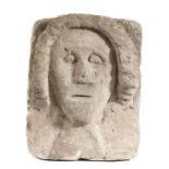 A carved 'limestone' head, possibly Norman/early Medieval, circa 1150-1300, with a roll of curled