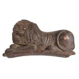 A large 18th century, or possibly earlier, carved pine and polychrome-decorated lion couchant, with
