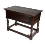 A Charles I oak box top or counter table, circa 1640, having a rectangular hinged plank top, above
