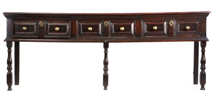 A good Charles II oak low dresser, circa 1680, the long rectangular top above three paired