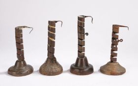 Four wrought iron and wooden candlesticks, French, circa 1800, each with a stem formed from a