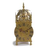An 18th Century and later brass lantern clock, the bell held under a frame with dolphin pierced