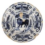 An 18th century Delft blue and white dish, centred by a standing lion with human face within an