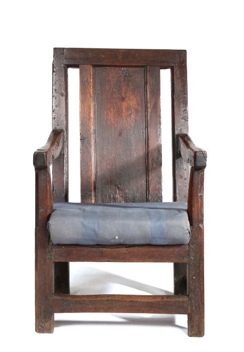 A joined oak panel-back open armchair, Welsh, circa 1700, having a plain back panel inset between