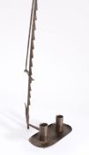 An 18th century wrought iron adjustable travelling candle holder, with hinged and ratchet arm, and