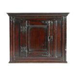 Charles II oak hanging cupboard, circa 1660, the concave cornice above a central panel door