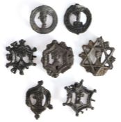 Seven 14th century pewter pilgrim/secular badges, each with the bust of man within a decorative
