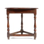 A small Queen Anne oak cricket-type table, circa 1710, the circular top above a moulded frieze and