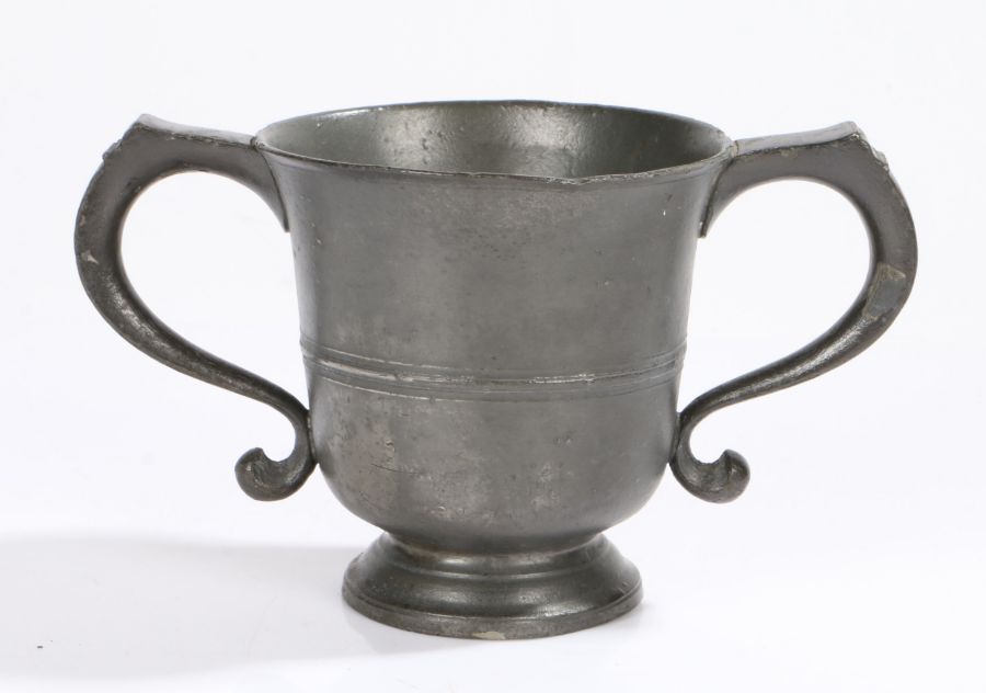 A George II twin-handled pewter ‘loving’-cup, circa 1750, the flared body with mid-fillet and
