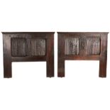 A pair of oak bed headboards, with 16th century panels Each with a pair of linenfold and ‘scale’-