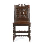 An unusual Charles II oak backstool, Lancashire,  circa 1660, with scroll profiled cresting above