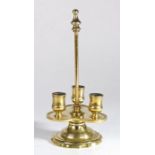 An unusual brass candlestick, with carrying handle and trefoil drip tray with three candle sockets,