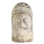 A carved stone head, in the Anglo-Saxon manner, with worn facial features, large eyes and broad