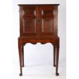 A particularly small Charles II oak enclosed chest of drawers, on a bespoke 18th century stand,