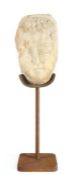 A carved marble head, in the Roman 1st to 3rd century CE manner, the elongated oval face with short