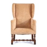 An 18th Century walnut and upholstered wing armchair, the shallow back, sides and  stuff-over seat